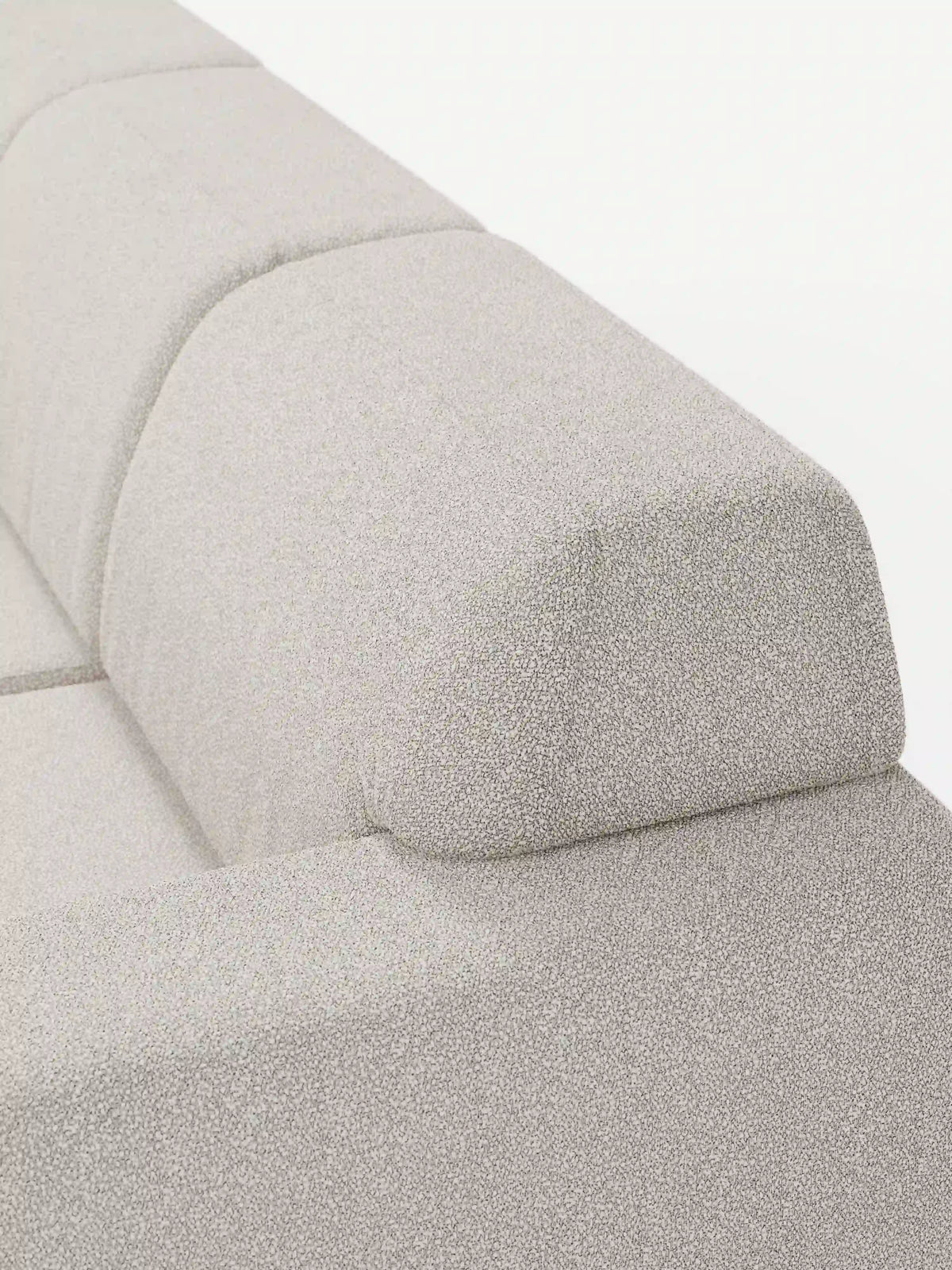 Primo piano di un divano in tessuto beige chiaro a trama rigata, come il modello Orbit con 3 sedute scorrevoli e allungabili in tessuto effetto cotone smacchiabile T33 di divitt.sbs, che mostra il bracciolo e parte dello schienale con linee pulite e squadrate e un'imbottitura morbida. L'immagine mette in risalto la raffinata trama del rivestimento, il suo design moderno e caratteristiche quali le sedute regolabili e allungabili in modo indipendente (sedute scorrevoli e allungabili) per una maggiore