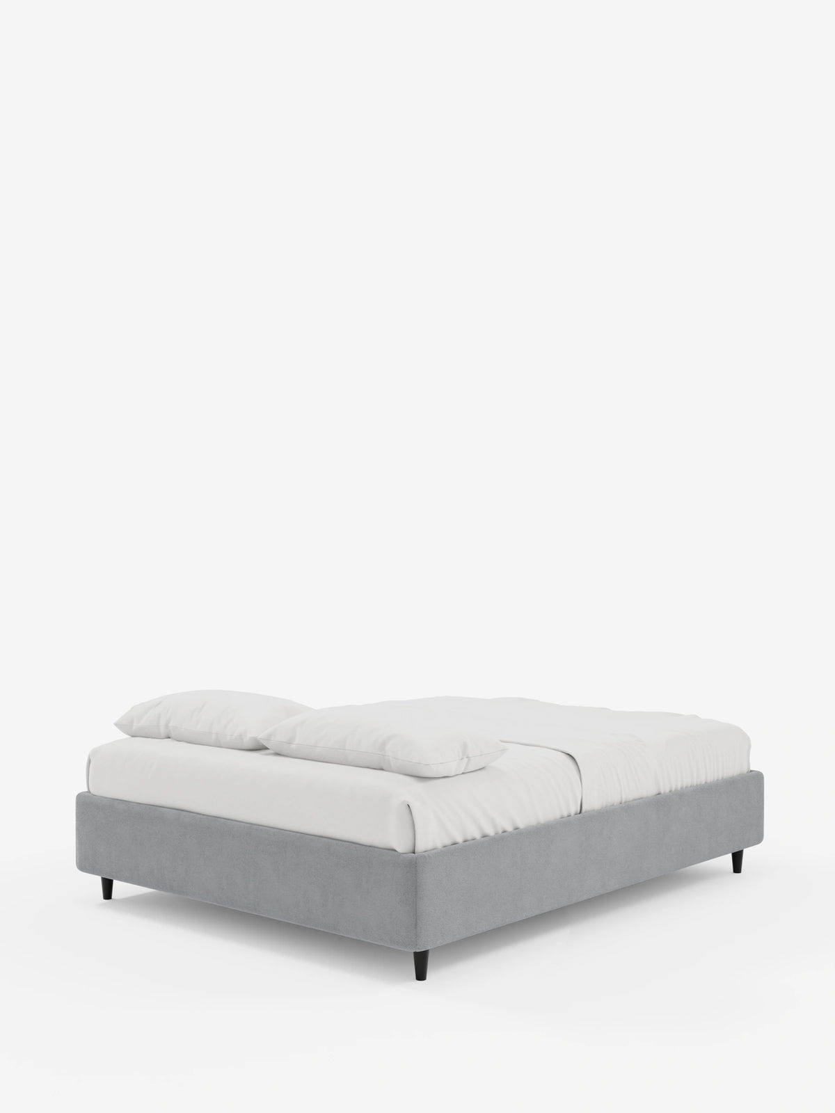 Vista laterale di un letto sommier imbottito ERON con contenitore, rivestito in tessuto impermeabile certificato Oeko-Tex di colore grigio con piccole gambe nere, adornato con lenzuola bianche immacolate e due cuscini su uno sfondo chiaro e semplice.