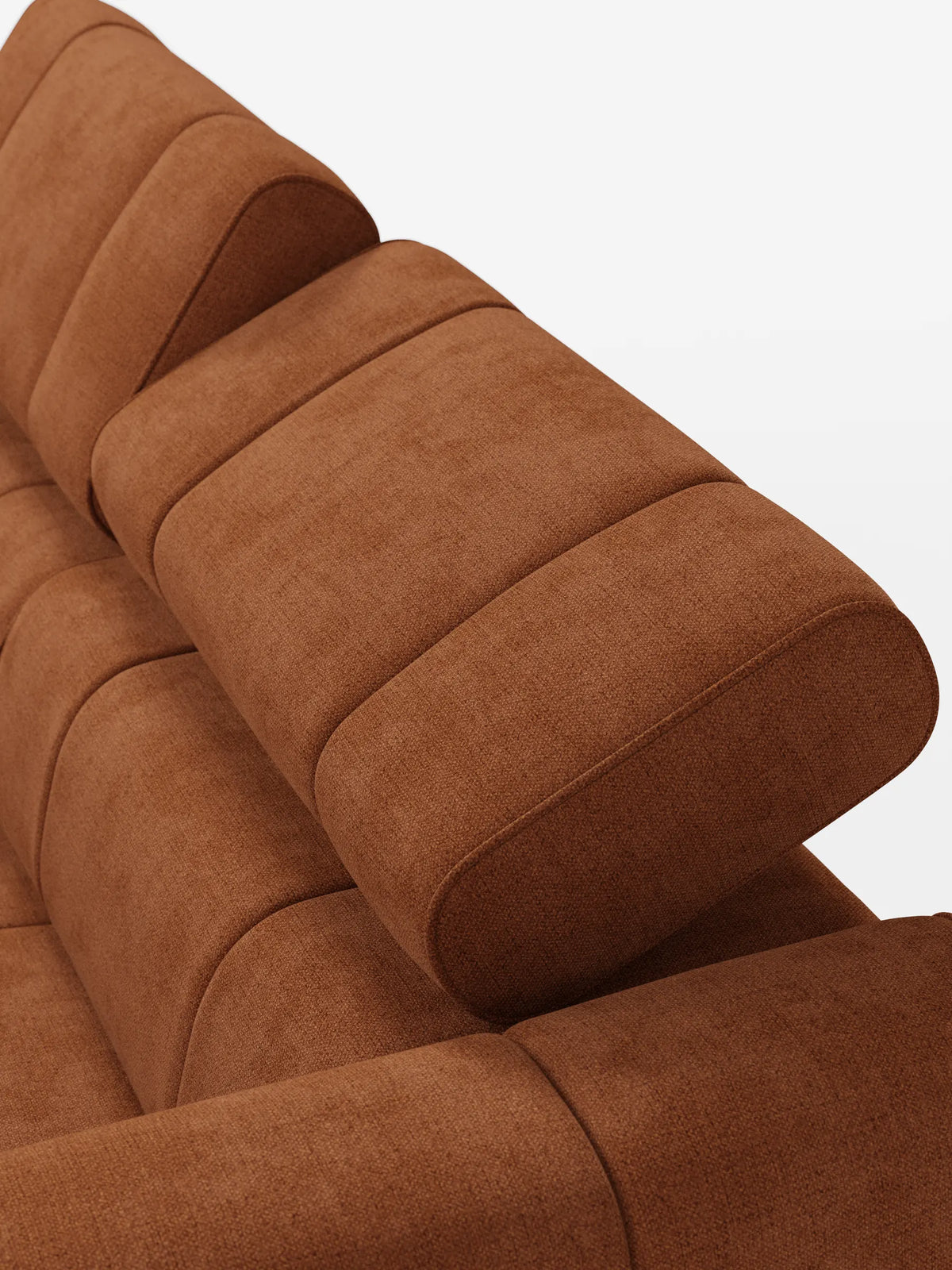 Primo piano dall'alto di un divano modulare Giotto a 3 posti color ruggine, con poggiatesta reclinabili e funzione relax elettrica opzionale, rivestito in tessuto smacchiabile T23, caratterizzato da schienali spessi e imbottiti e poggiatesta regolabili su uno sfondo bianco.
