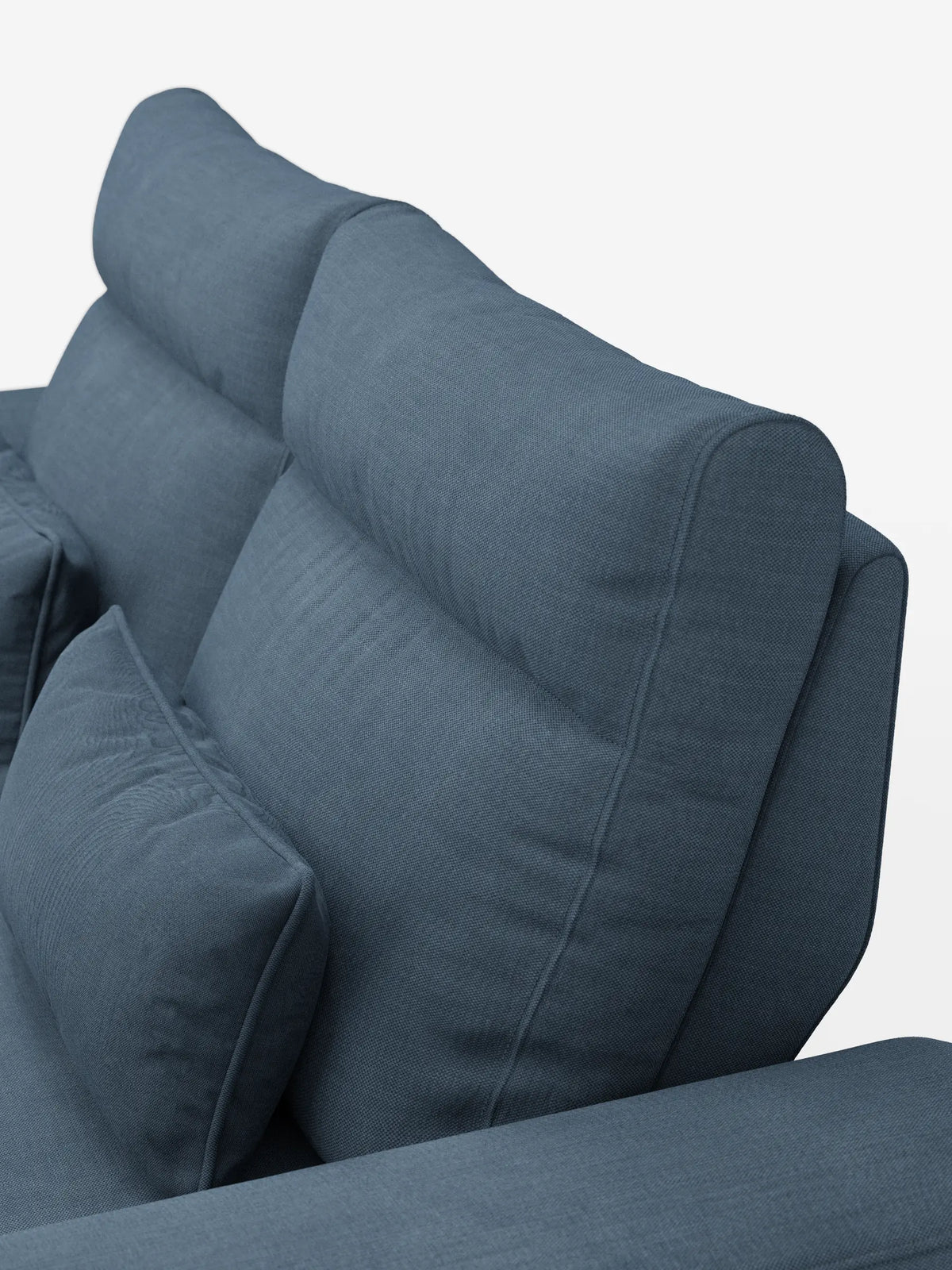 Una vista laterale dall'alto del divano Ischia a 3 posti con pouf estraibile e schienali traslanti in tessuto misto lino smacchiabile in una tonalità tenue di blu-grigio, caratterizzato da un rivestimento liscio e testurizzato e da schienali traslanti regolabili su uno sfondo bianco.