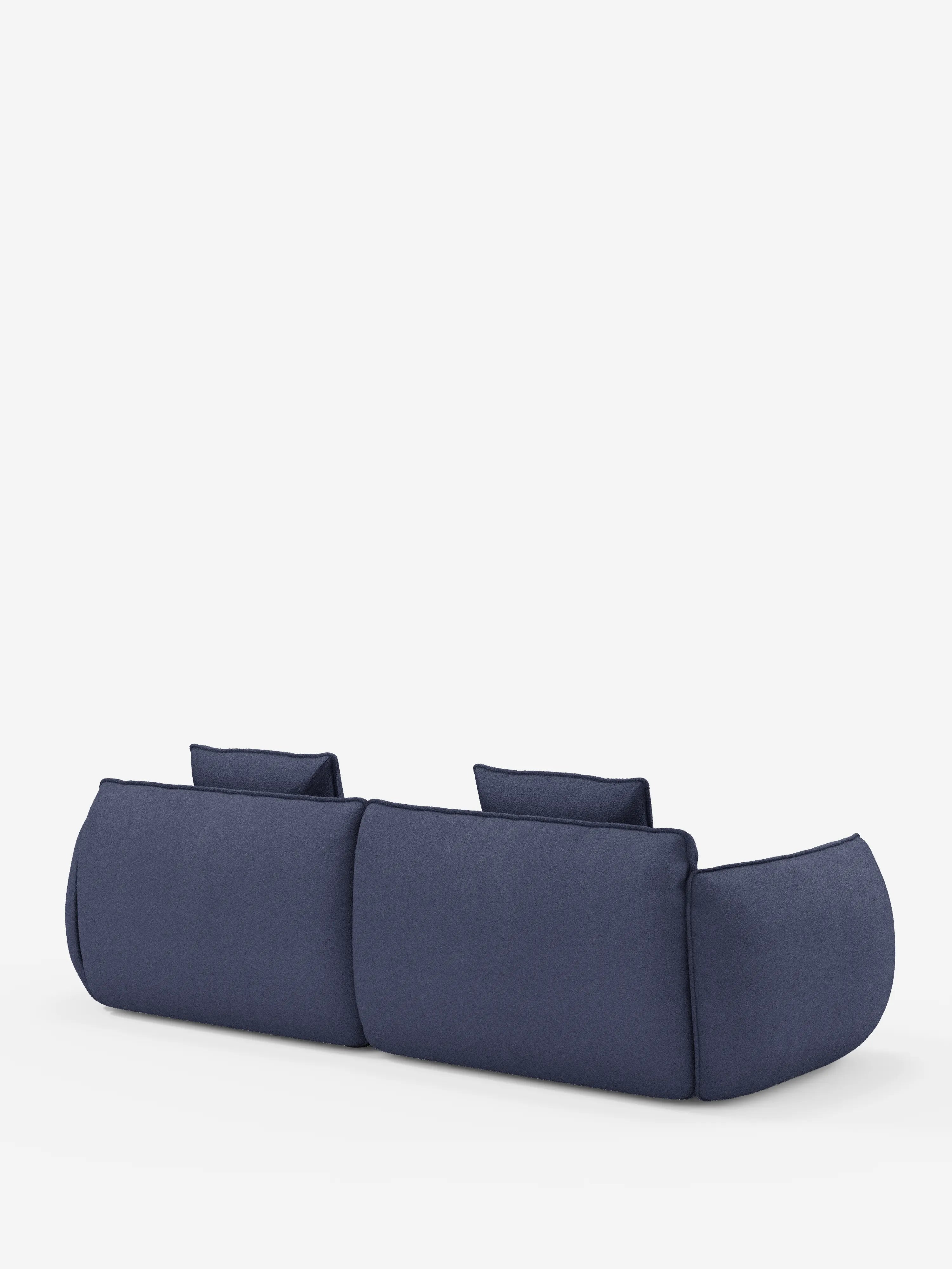 Un divano a 3 posti moderno e minimalista della linea Nimbus, modulare e componibile da 250 cm di divitt.sbs, rivestito in tessuto sfoderabile e antimacchia effetto cotone (t33) di colore blu navy. Il divano presenta bordi morbidi e arrotondati, due ampie sezioni di seduta, schienali bassi e fianchi imbottiti e spessi. Fotografato di retro su sfondo bianco per enfatizzarne la forma e il colore.