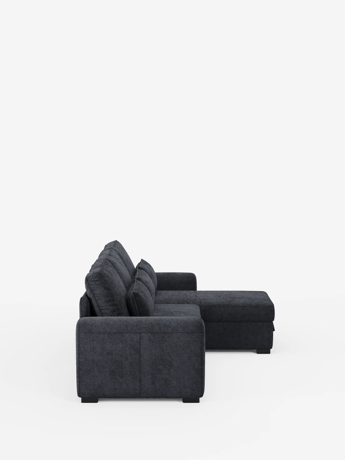 Un divano letto Ottaviano grigio scuro con letto estraibile – penisola reversibile e contenitore in tessuto materico smacchiabile con chaise longue – si staglia su uno sfondo bianco a tinta unita, caratterizzato da spessi cuscini dello schienale, braccioli squadrati e piedini bassi a blocco.