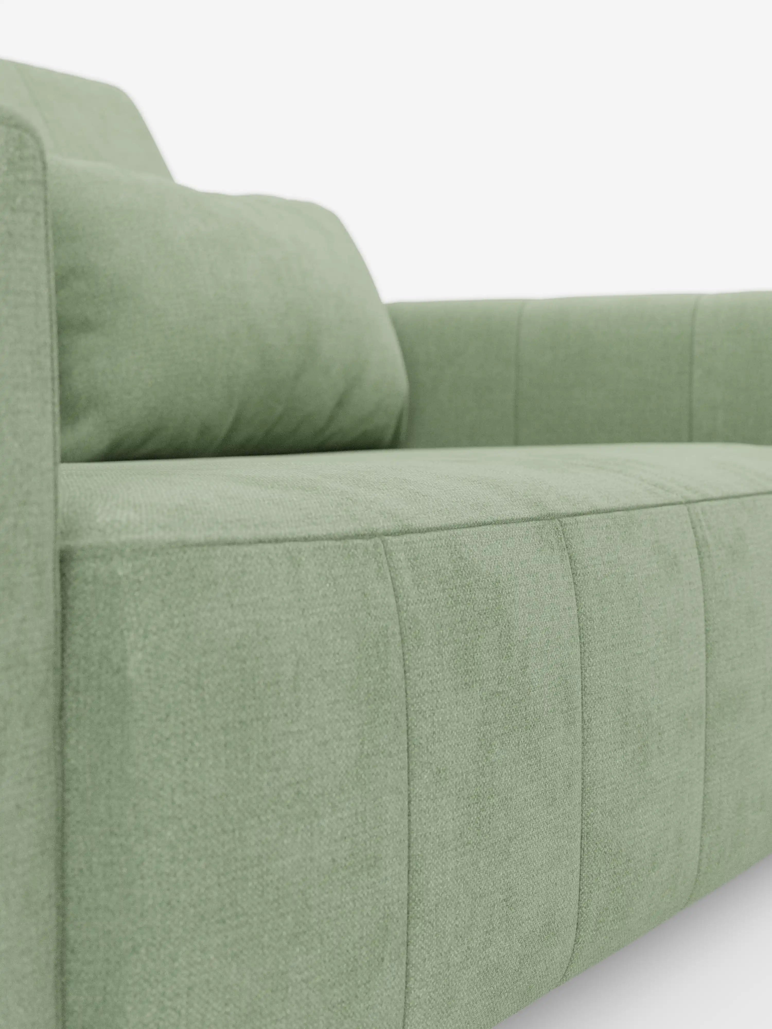Primo piano del divano dorico a 3 posti con sedute allungabili tramite meccanismo relax elettrico di divitt.sbs, rivestito in tessuto T23 verde chiaro, facile da pulire. Il divano presenta linee moderne e pulite, con braccioli e seduta imbottiti, completati da un poggiatesta reclinabile e da sottili dettagli di cuciture sul tessuto. Sullo sfondo bianco a tinta unita, il colore e la trama del divano risaltano magnificamente.