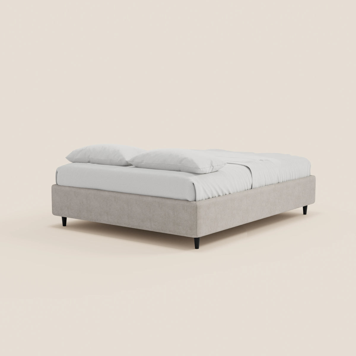 Il letto sommier imbottito ERON di Letti.store presenta una struttura dal profilo basso in tessuto impermeabile color beige chiaro certificato Oeko-Tex, biancheria da letto bianca con due cuscini, ed è sostenuto da quattro gambe corte nere su uno sfondo chiaro e semplice.