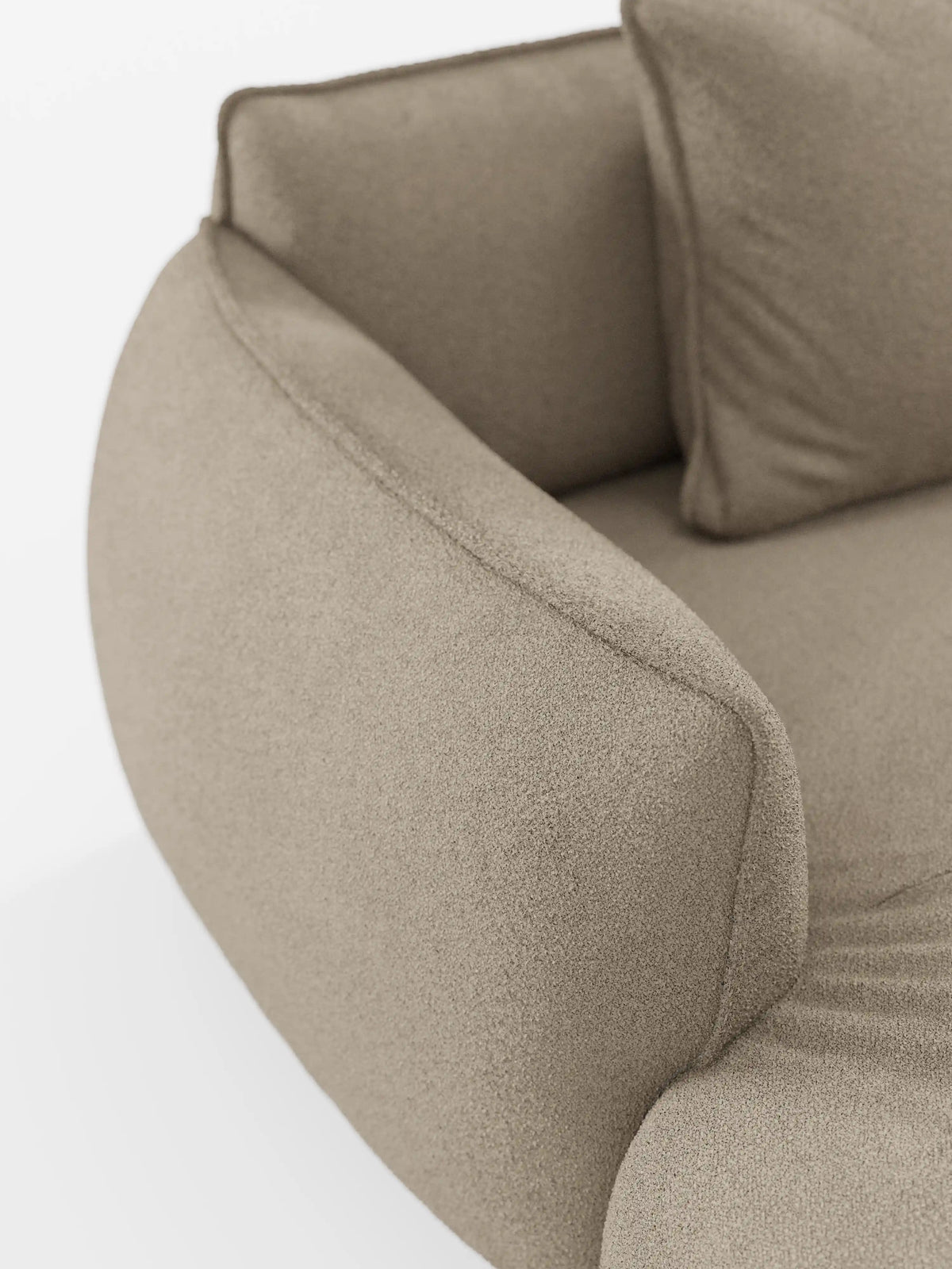 Primo piano del divano angolare panoramico componibile Nimbus con penisola e angolo in tessuto smacchiabile T33 di divitt.sbs, caratterizzato da una moderna imbottitura beige con bracciolo ricurvo e cuscino decorativo abbinato. Il tessuto morbido e testurizzato conferisce un aspetto accogliente e invitante, che richiama lo stile di un divano modulare contemporaneo e di facile pulizia. Su uno sfondo bianco, il design e i dettagli di questo elegante complemento d’arredo risaltano magnificamente.