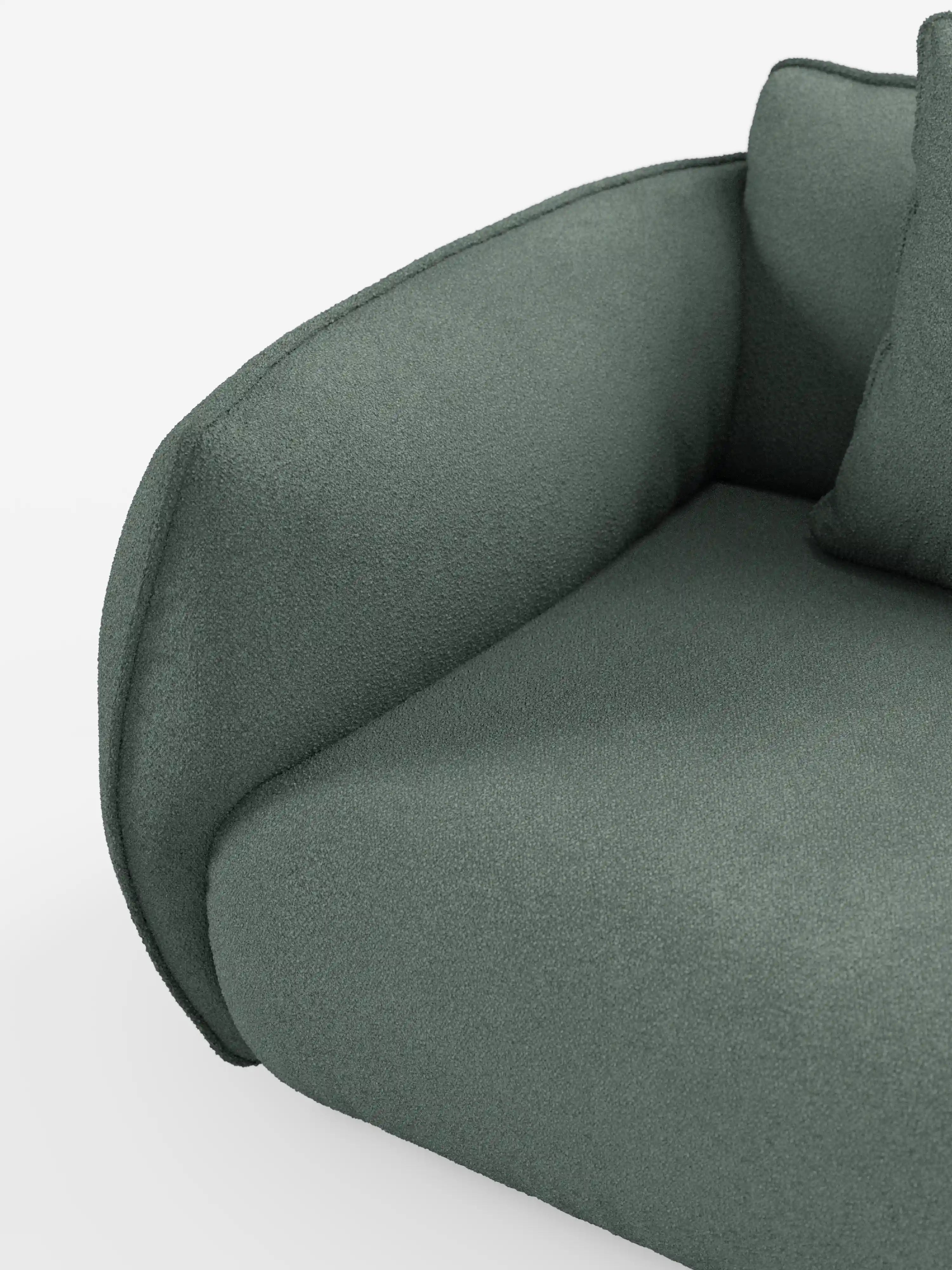 Primo piano del divano angolare Nimbus di divitt.sbs con penisola componibile, realizzato in morbido tessuto effetto cotone smacchiabile T33, con particolare attenzione al bracciolo sinistro e al cuscino di seduta rivestiti in verde. Il tessuto effetto cotone appare morbido e materico, con bordi lisci e arrotondati, e un cuscino dello schienale in tinta, parzialmente visibile su uno sfondo bianco a tinta unita.