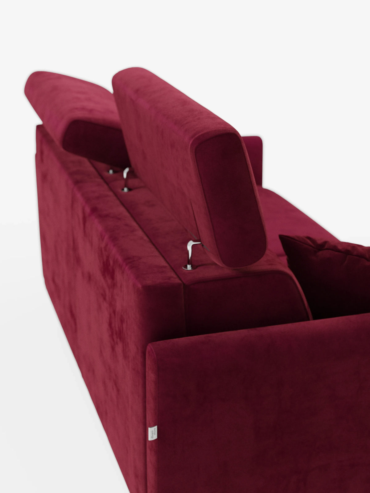 Un lussuoso divano letto Francy di colore rosso intenso con poggiatesta regolabili di divitt.sbs, caratterizzato da due poggiatesta regolabili inclinati verso l’alto. L'elegante tessuto T30, resistente alle macchie, è vellutato, dalla consistenza morbida e dotato di fodere completamente sfoderabili. L'immagine è ripresa da dietro, mettendo in risalto il meccanismo dei poggiatesta e parte di un cuscino su uno sfondo bianco a tinta unita.