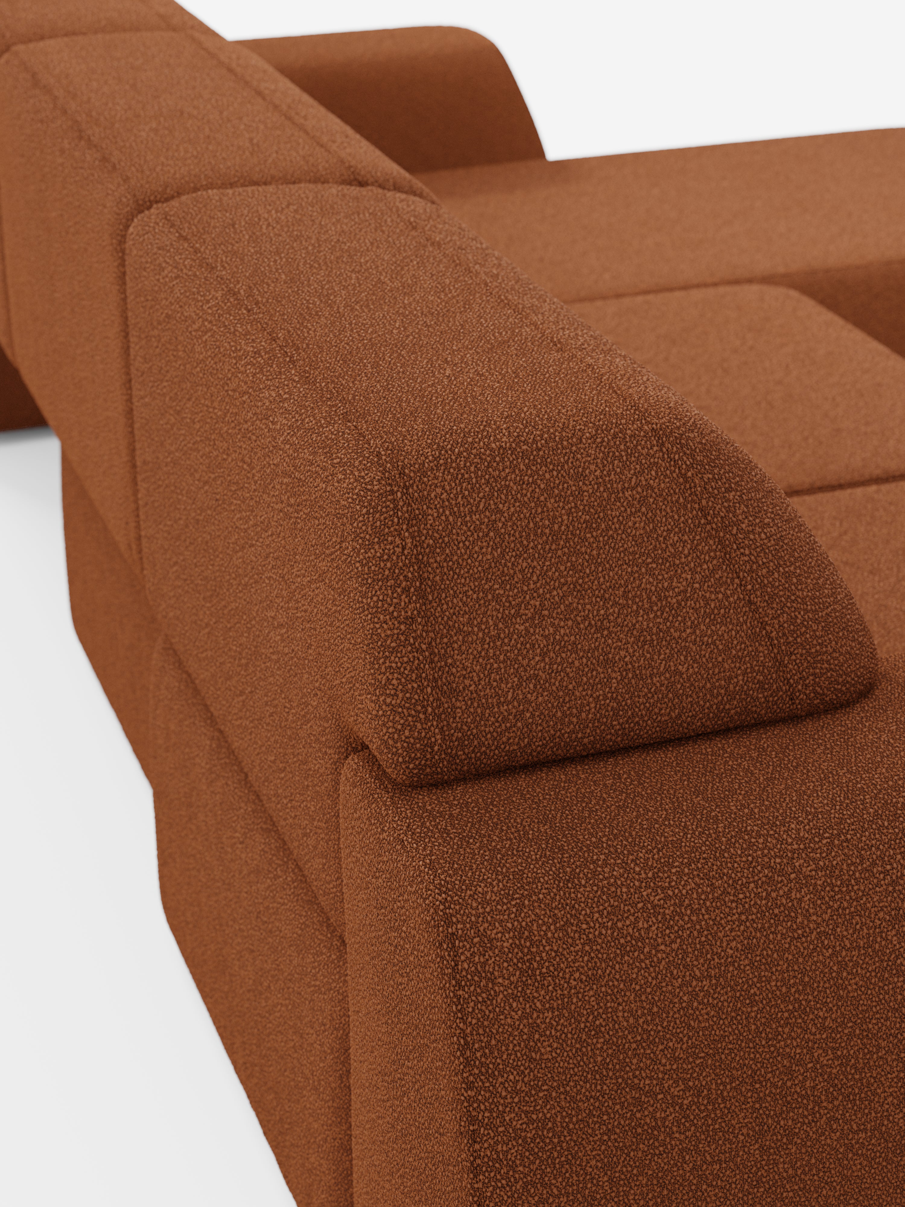 Un primo piano del divano angolare Orbit con penisola reversibile e tutte le sedute allungabili in tessuto smacchiabile effetto cotone T33 di divitt.sbs ne mette in risalto il design moderno e modulare, caratterizzato da un rivestimento testurizzato effetto cotone. L'immagine mette in risalto le linee pulite, la forma geometrica squadrata e i cuscini dei braccioli e della seduta angolari di questo divano di alta gamma su uno sfondo bianco.