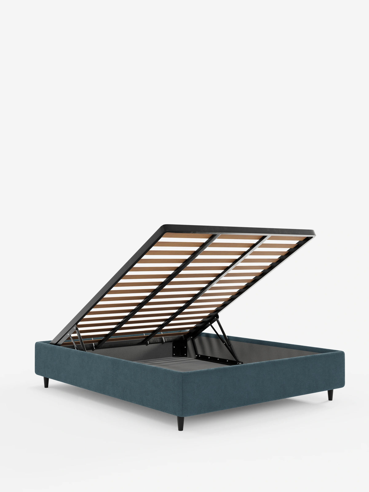 Il letto sommier imbottito ERON con vano contenitore in tessuto impermeabile certificato Oeko-Tex è raffigurato in blu con la rete a doghe sollevata per rivelare uno scomparto cavo, appoggiato su quattro gambe corte e scure su uno sfondo bianco.