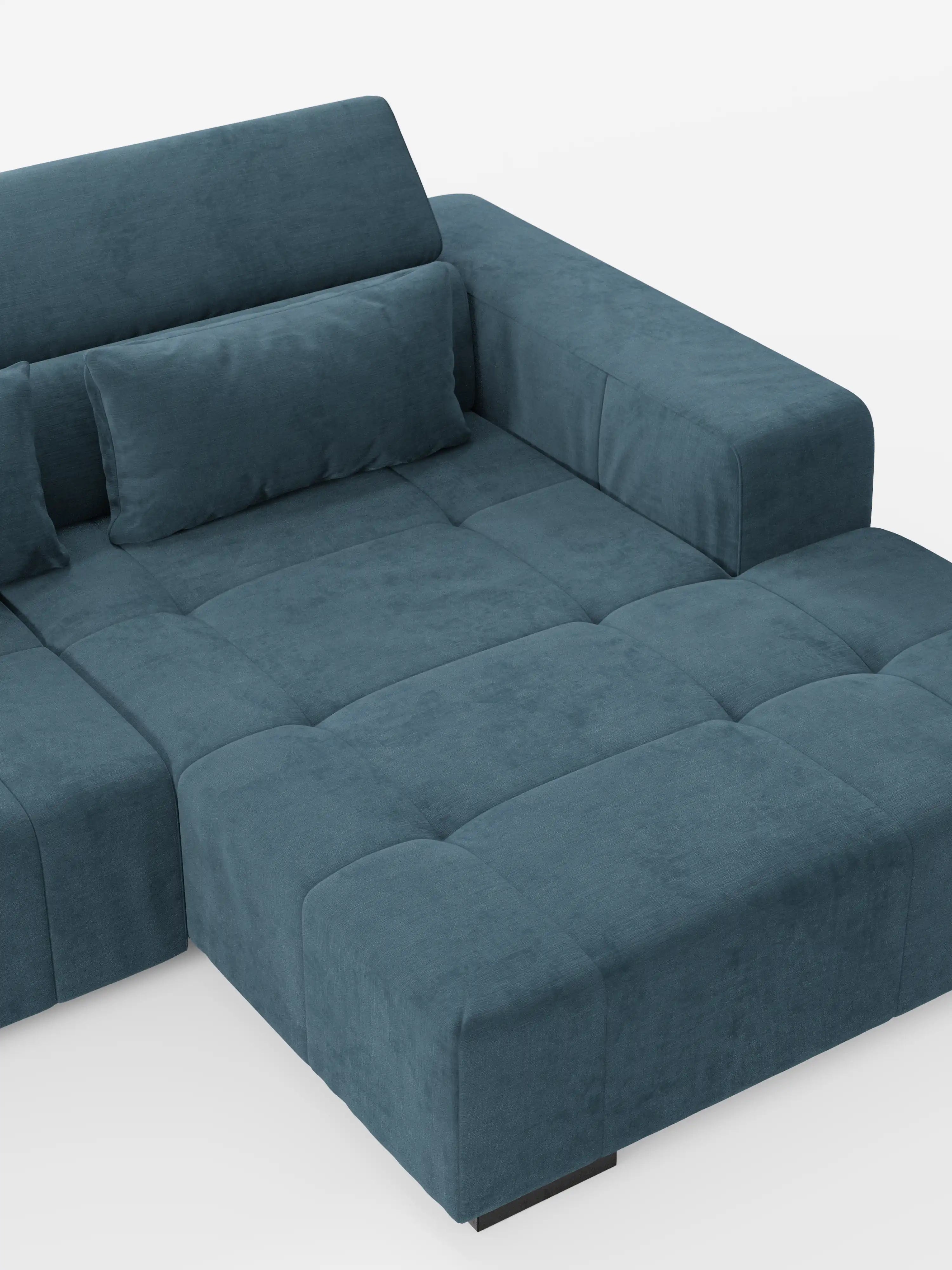 Il divano angolare Monarch con penisola e funzione Relax Elettrico per l'allungamento delle sedute di divitt.sbs è realizzato in tessuto T31 blu verde acqua, morbido e resistente alle macchie. Presenta braccioli ampi e squadrati, sedute profonde trapuntate, uno schienale dritto con poggiatesta reclinabili ed è corredato da un cuscino rettangolare abbinato. Lo sfondo è bianco a tinta unita.