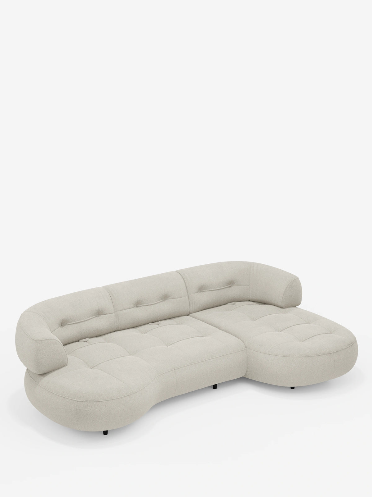 Un divano angolare Croissant color beige chiaro, dal design a forma di fagiolo e con schienali scorrevoli, rivestito in morbido tessuto effetto cotone smacchiabile T33, caratterizzato da una struttura curva a basso profilo a forma di fagiolo, con cuscini di seduta trapuntati e schienali arrotondati con bottoni decorativi.