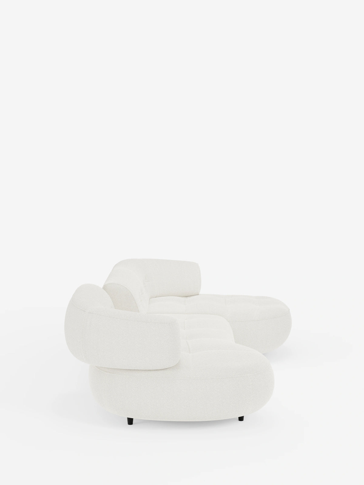 Un divano angolare Croissant color crema dal design a forma di fagiolo e con schienali scorrevoli in morbido tessuto effetto cotone smacchiabile T33, caratterizzato da un design arrotondato a forma di fagiolo e da schienali bassi su uno sfondo bianco a tinta unita.