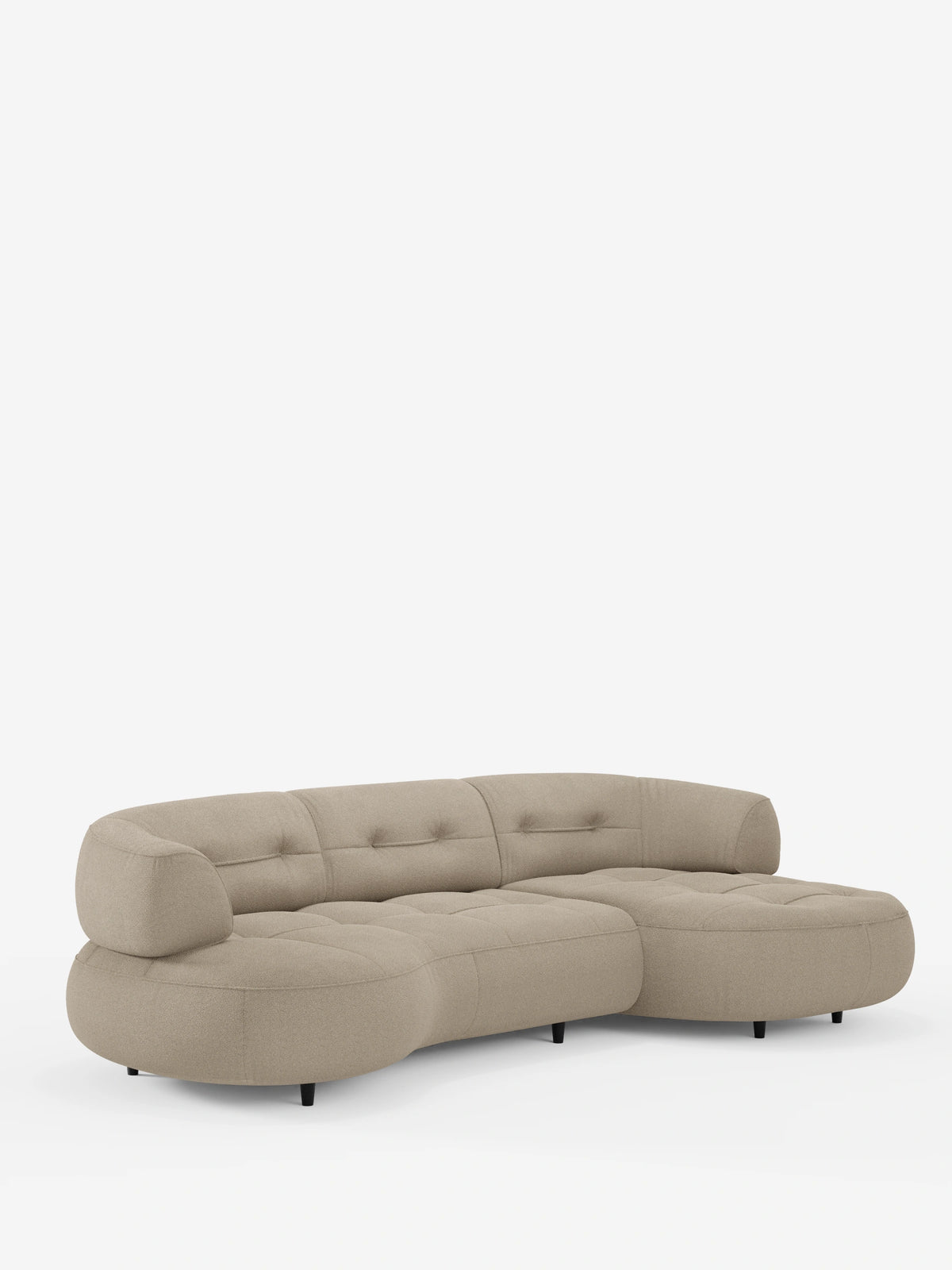 Un divano angolare Croissant beige a forma di fagiolo, con schienali scorrevoli in morbido tessuto effetto cotone smacchiabile T33, caratterizzato da dettagli trapuntati, bordi arrotondati e schienali bassi su gambe corte e cilindriche di colore nero.