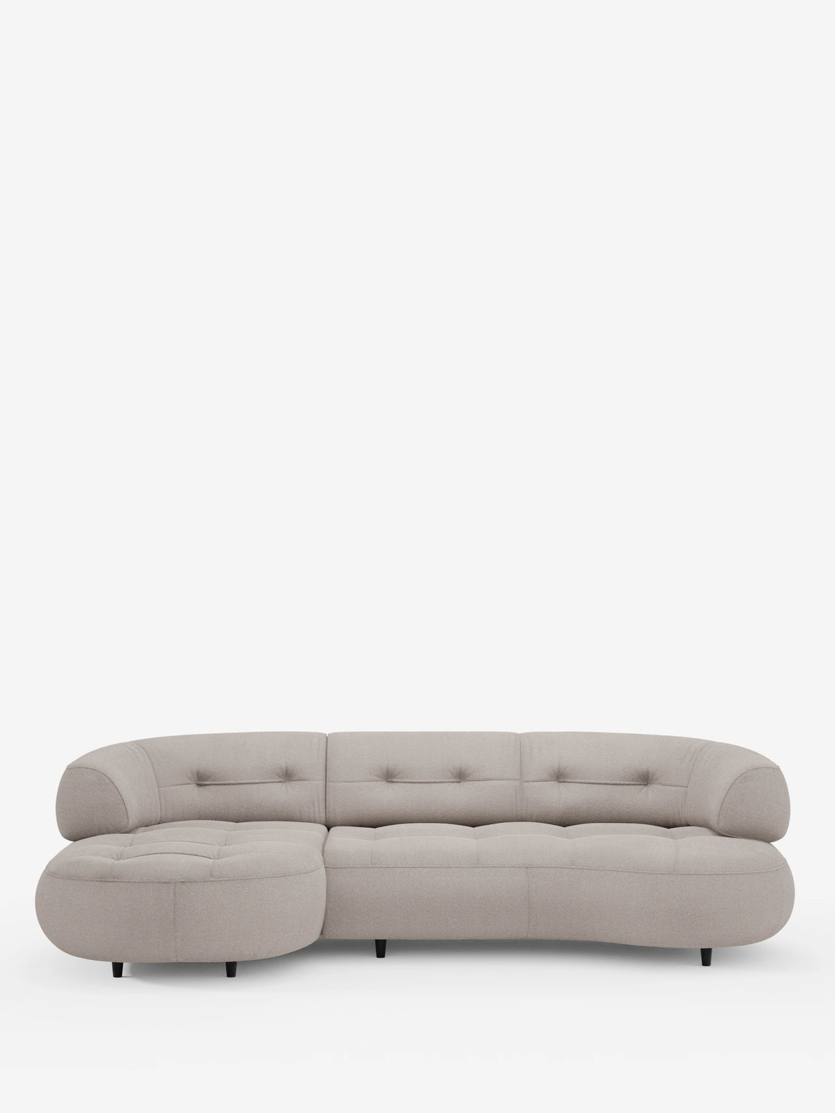 Un divano angolare Croissant beige dalle linee curve, con design a fagiolo e schienali traslanti in morbido tessuto effetto cotone smacchiabile T33, dotato di chaise longue arrotondata, tessuto trapuntato, schienali bassi e gambe cilindriche scure su sfondo bianco.
