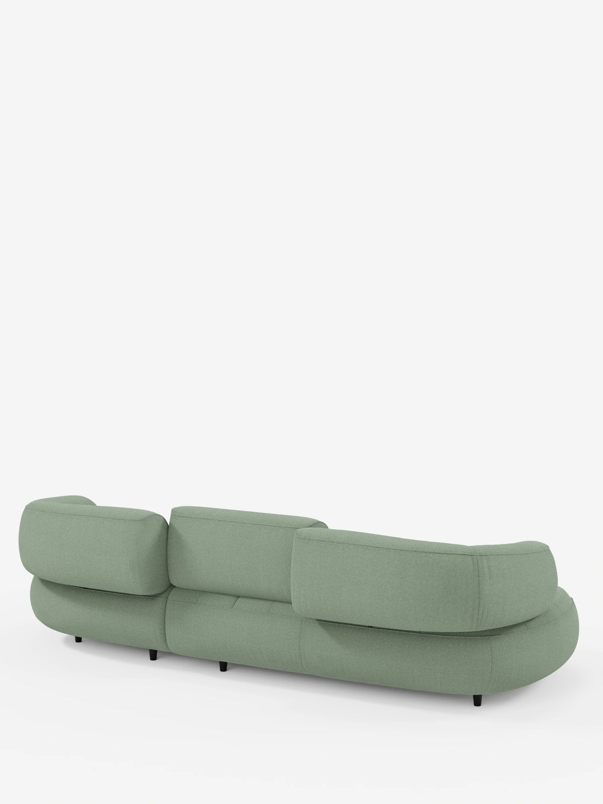 Un divano angolare Croissant dalla forma ricurva a fagiolo, con schienali scorrevoli in morbido tessuto effetto cotone smacchiabile T33 color verde salvia, si staglia su uno sfondo bianco con tre cuscini rettangolari per lo schienale e gambe scure.