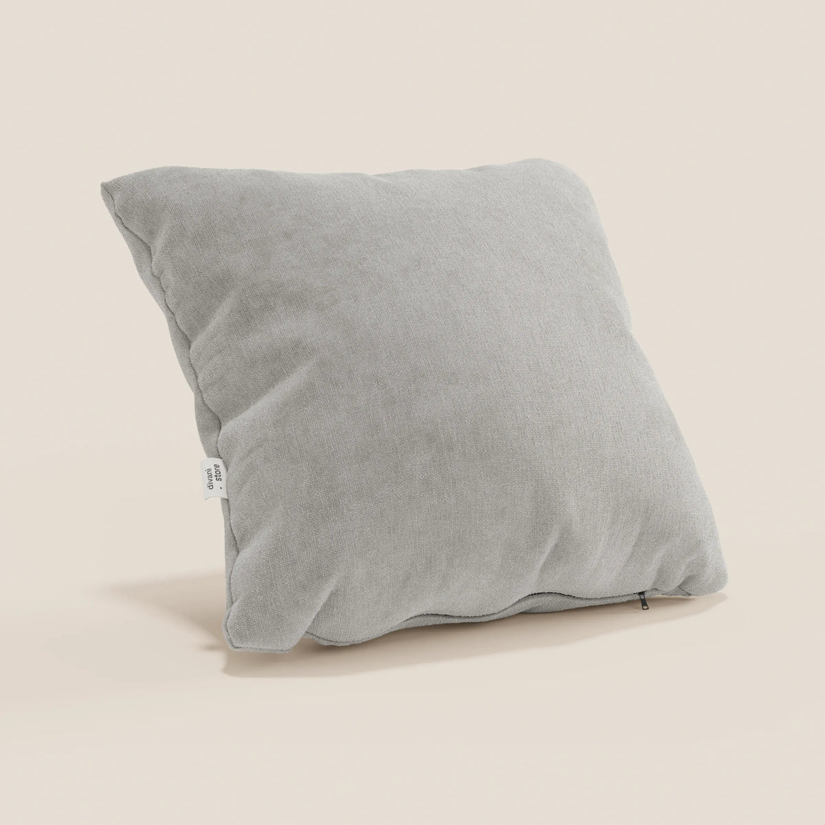 Il cuscino Bolero di divitt.sbs, in morbido tessuto grigio chiaro T31 antimacchia, impermeabile e non restringente, è quadrato e verticale su sfondo beige. Lungo il bordo sono visibili una targhetta bianca e una sottile cerniera. Disponibile in vari colori.