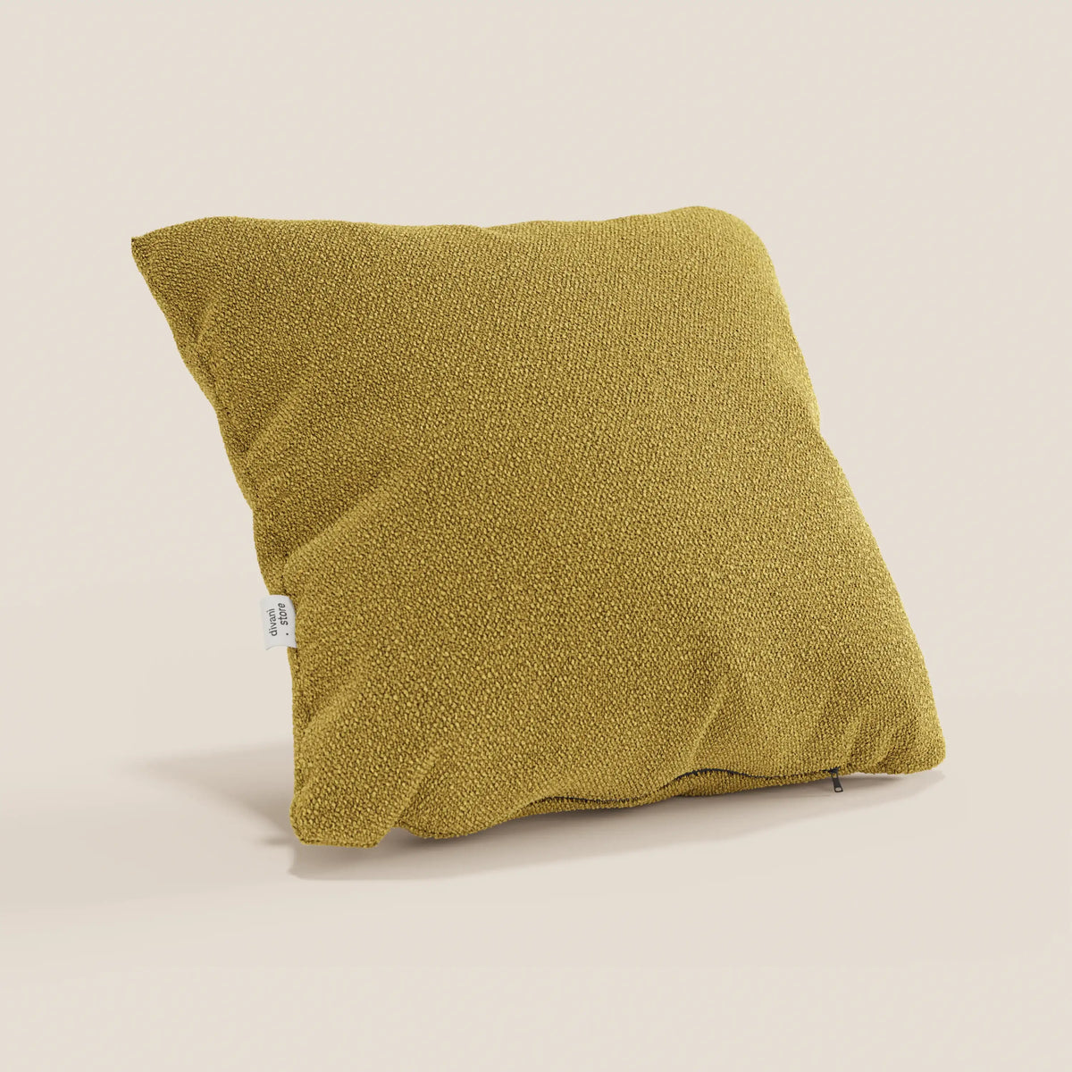Il cuscino quadrato Lambada giallo senape di divitt.sbs, realizzato in fresco tessuto simil-cotone T33 antimacchia e impermeabile a effetto naturale, è posizionato ad angolo con una piccola etichetta bianca e una texture visibile per un look accogliente e moderno.