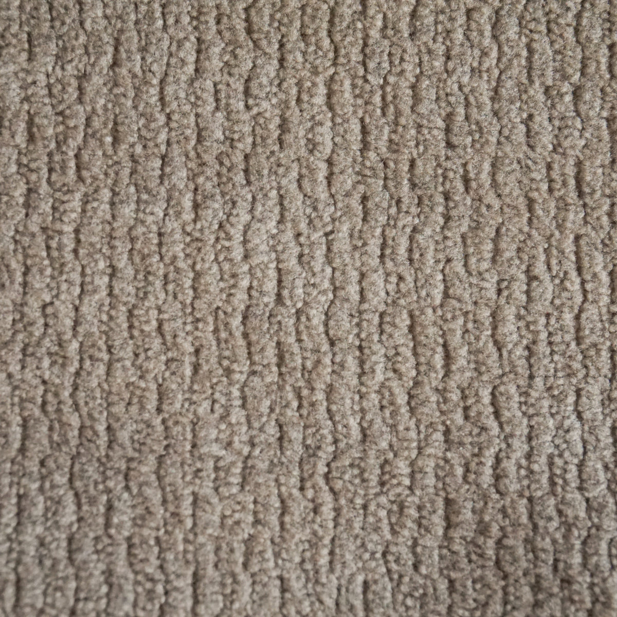 Primo piano sul tessuto beige a trama ruvida della collezione Personalizzazione in T32 KENDAL, caratterizzato da un motivo a coste verticali ripetuto con profonde scanalature tra le colonne di morbide fibre tuftate.
