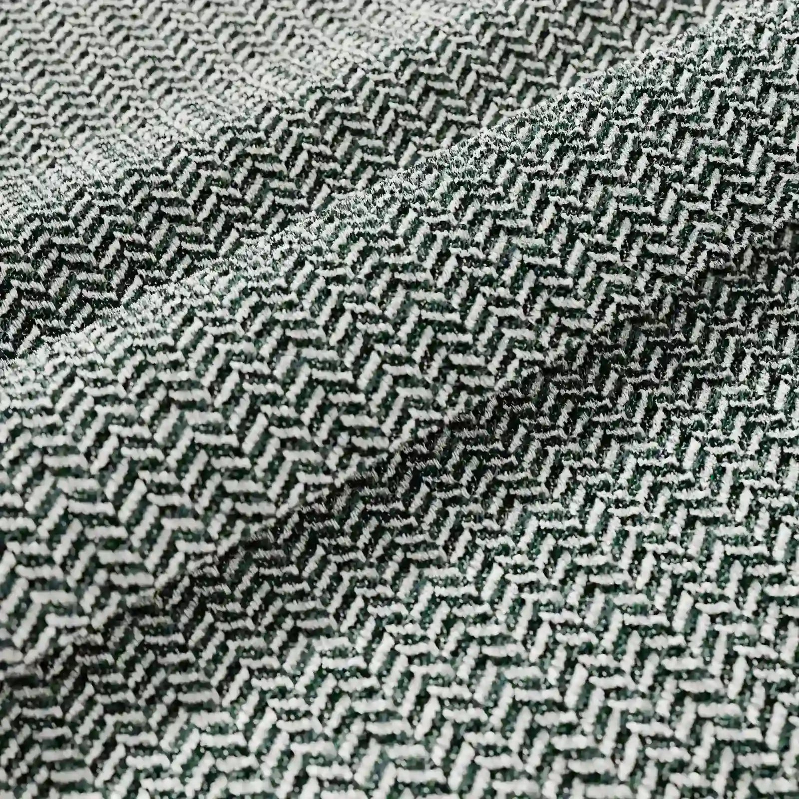 Primo piano del cuscino Sorrento 45x45 in lino di divitt.sbs, che mette in risalto la trama a spina di pesce con fili verde scuro e bianchi: ideale per cuscini lavabili in lavatrice. L'elegante piega esalta il suo design geometrico e ricco di texture.