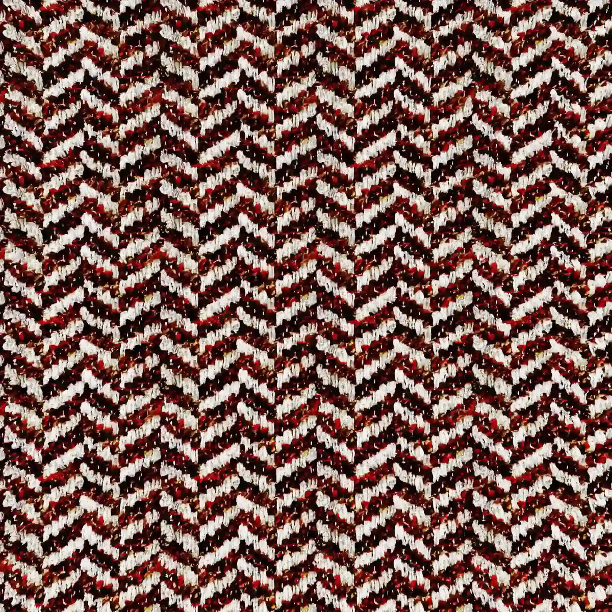 Un'immagine dettagliata del cuscino Sorrento 45x45 in lino di divitt.sbs mette in risalto il suo motivo a chevron nei colori rosso, nero, bianco e beige, che crea un dinamico effetto a spina di pesce grazie alle fibre di lino testurizzate e leggermente in rilievo.
