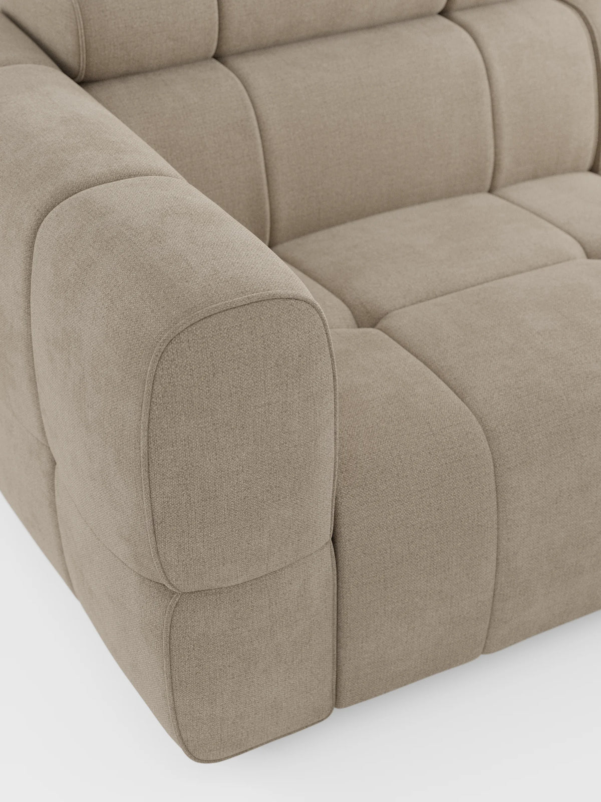 Un primo piano del divano angolare modulare Giotto a 5 posti da 296 cm con penisola e funzione relax elettrica opzionale, rivestito in tessuto smacchiabile T23, caratterizzato da tessuto beige, braccioli imbottiti e profonde sezioni di seduta quadrate trapuntate su uno sfondo bianco a tinta unita.