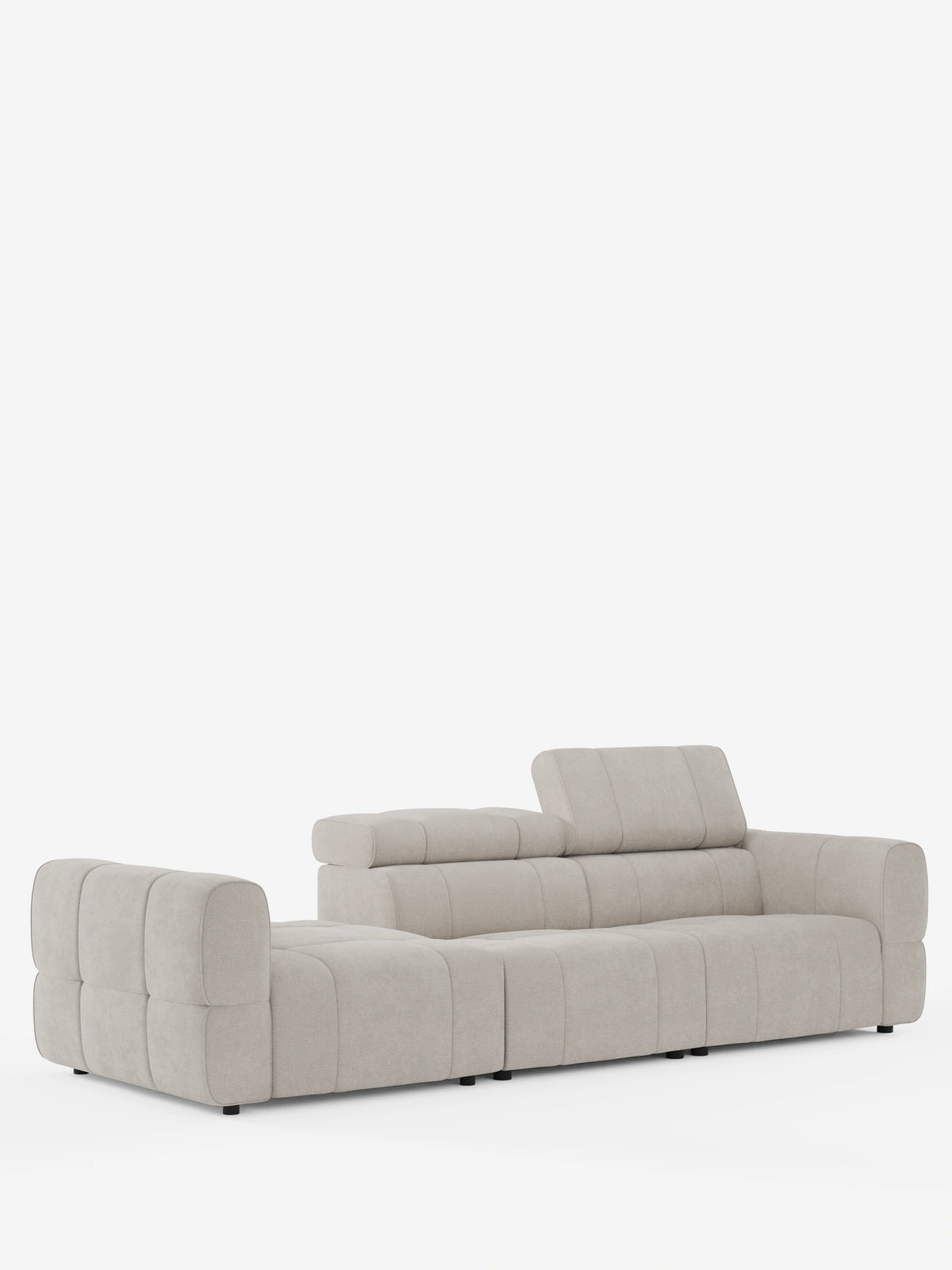 Un divano componibile Giotto Divano color beige chiaro con estremità aperta – opzione relax elettrico in tessuto smacchiabile T23 – è raffigurato su uno sfondo bianco; presenta un design dal profilo basso con cuscini cuciti a griglia e un poggiatesta regolabile.