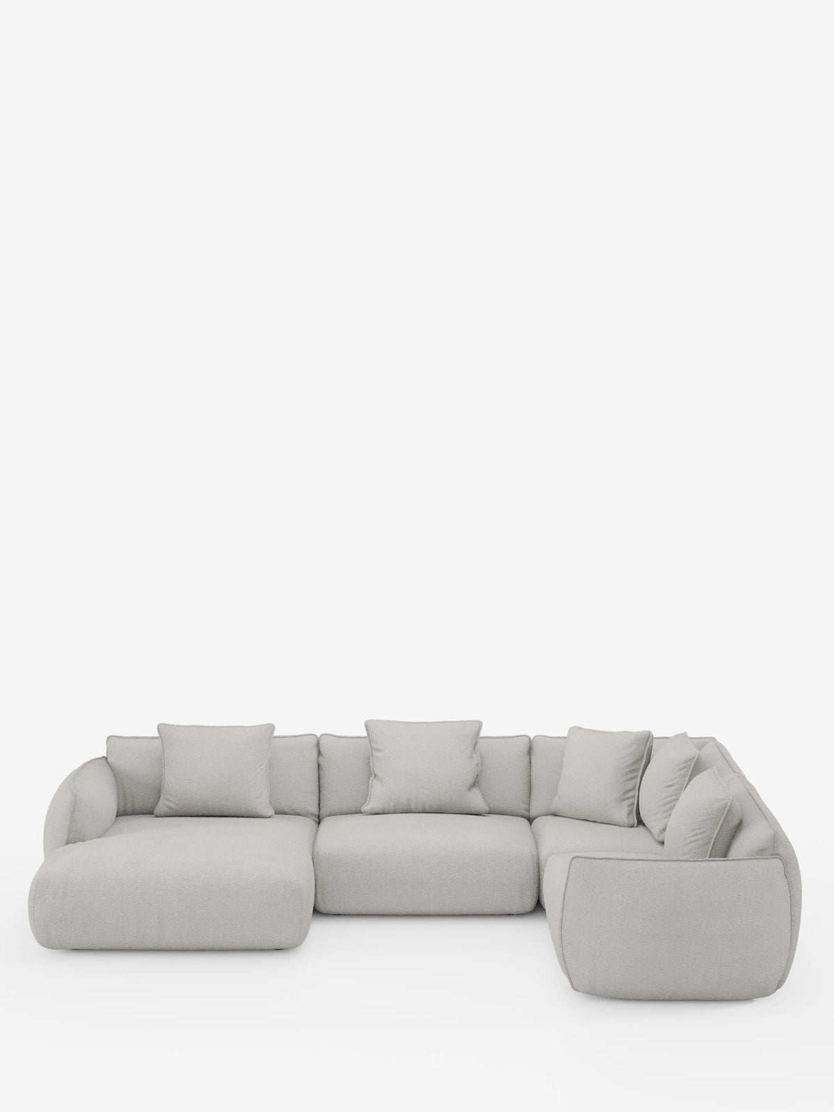 Il divano angolare panoramico componibile Nimbus con penisola e angolo in tessuto smacchiabile t33 di divitt.sbs si presenta con un design moderno in grigio chiaro e morbidi cuscini disposti a forma di L. Questo divano componibile è caratterizzato da uno schienale basso, ampi braccioli e una silhouette morbida e minimalista che risalta su uno sfondo bianco a tinta unita. Cinque cuscini quadrati coordinati completano l’elegante composizione.