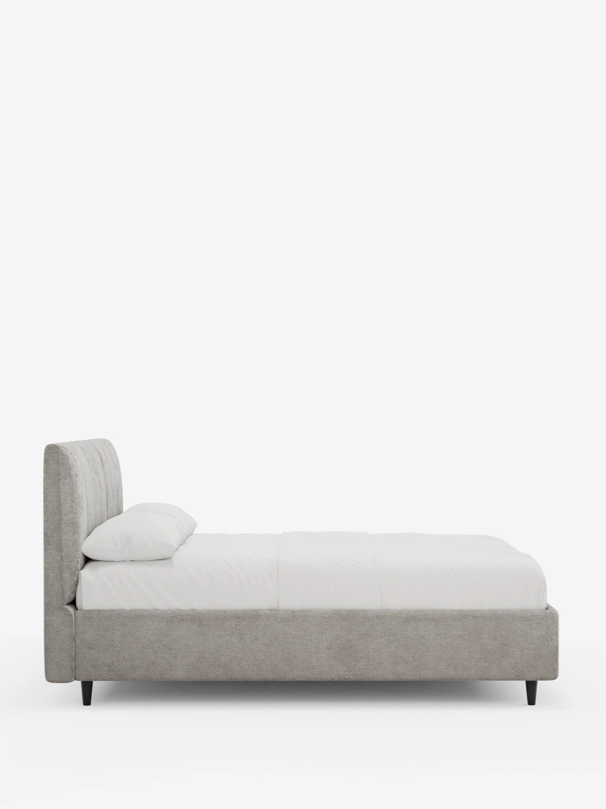 Vista laterale di un letto imbottito ONYX con contenitore e testiera verticale in tessuto certificato Oeko-Tex®, caratterizzato da una testiera alta e a pannelli verticali di colore grigio chiaro, lenzuola bianchissime e semplici piedini neri su uno sfondo bianco.