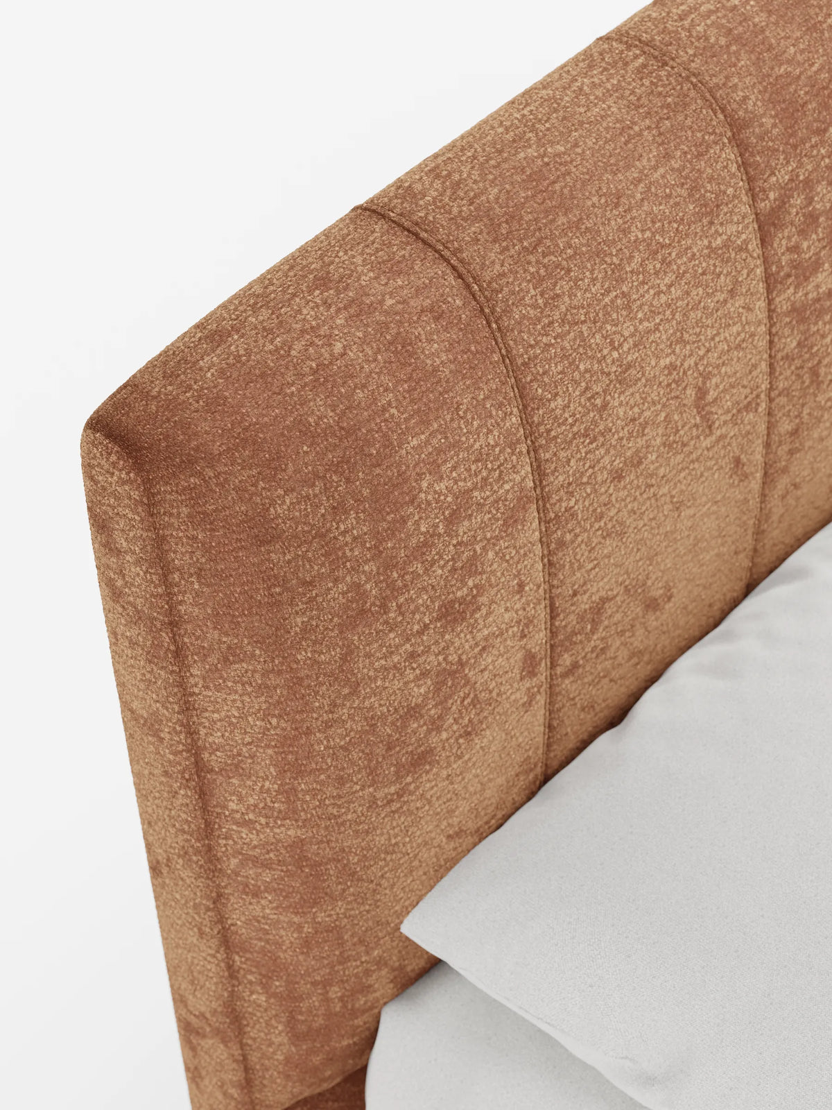 Primo piano del letto imbottito ONYX con contenitore e testiera verticale in tessuto certificato Oeko-Tex®, caratterizzato da cuciture verticali e da un tessuto dalla trama ruvida color rame-marrone, con un cuscino grigio chiaro su uno sfondo bianco a tinta unita.