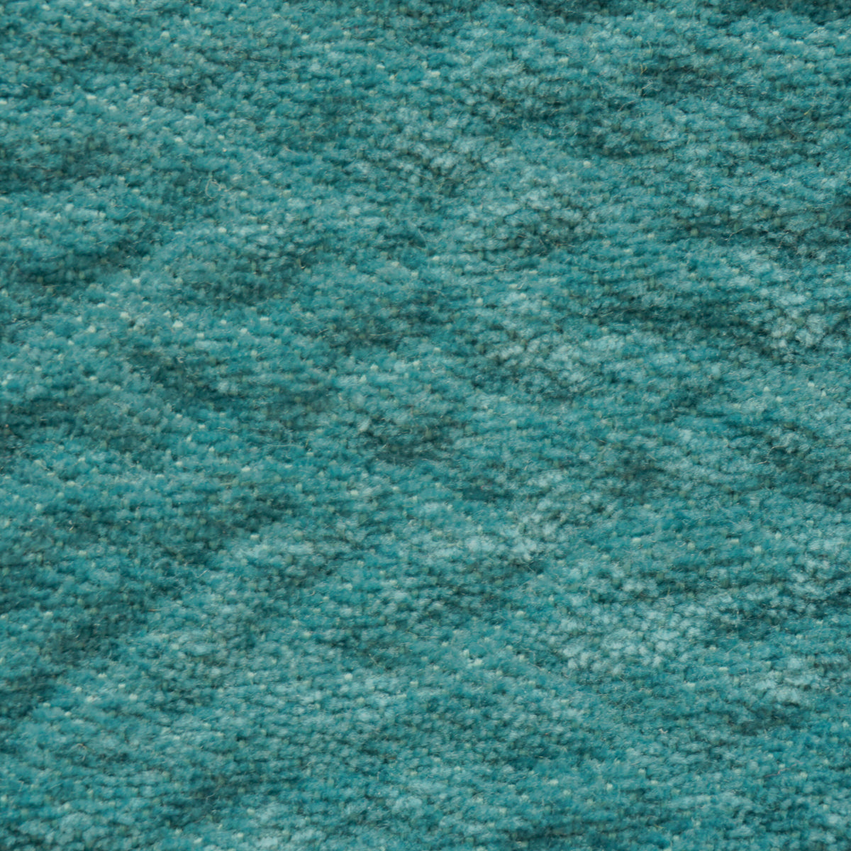 Un primo piano del tessuto verde acqua, denso e a ciuffetti, della linea “Personalizzazione” in T27 BREZZA, caratterizzato da una superficie morbida e irregolare con variazioni di intensità cromatica che conferiscono un aspetto soffice e piacevole al tatto.