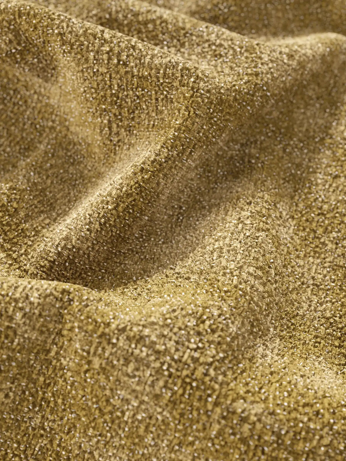 Primo piano del tessuto dalla trama marrone dorato su un divano letto Ottaviano con letto estraibile - penisola reversibile e contenitore in tessuto materico lavabile, caratterizzato da morbide pieghe, un delicato luccichio e una trama fitta e multidimensionale.