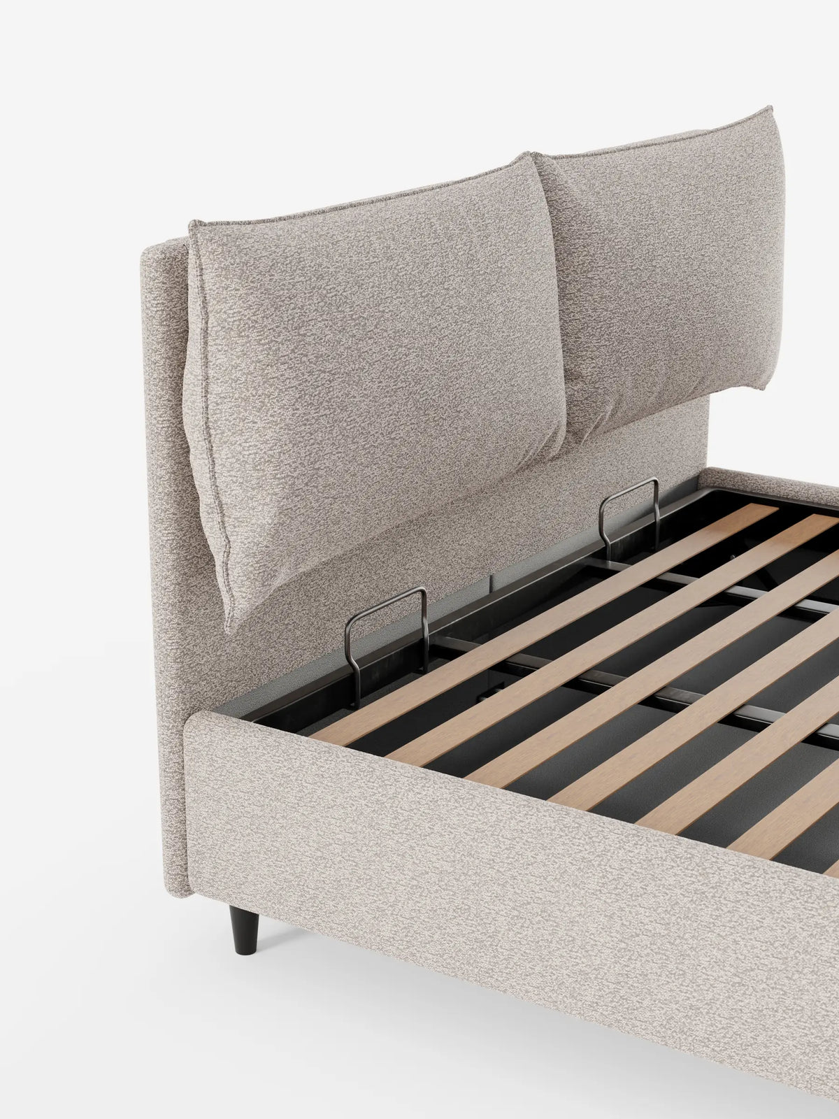 Il letto imbottito ZAYRON, di colore beige e dalla trama ruvida, dotato di vano contenitore e morbidi cuscini regolabili, presenta due cuscini regolabili sulla testiera; la sua base è aperta e lascia intravedere le doghe in legno e un vano contenitore nascosto su uno sfondo a tinta unita.