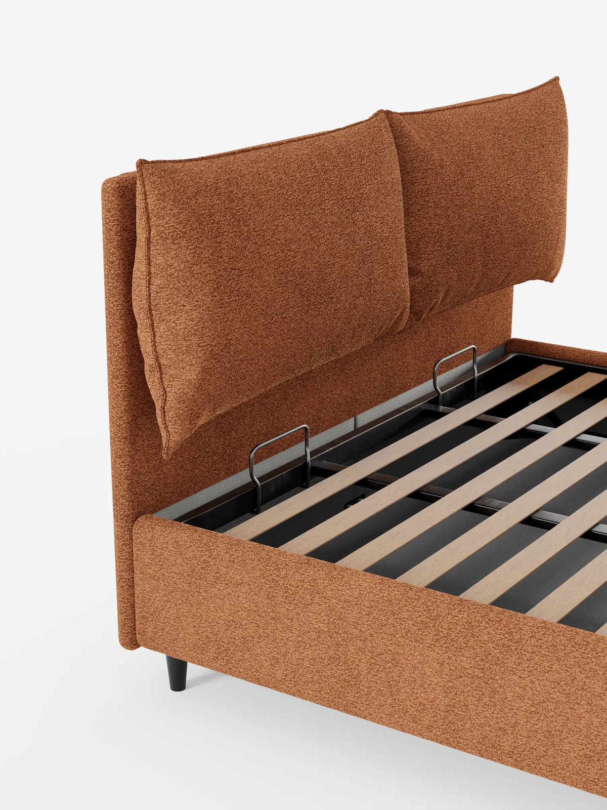 ZAYRON: letto imbottito con contenitore e morbidi cuscini regolabili in tessuto color ruggine, dotato di testiera regolabile con cuscini integrati, base aperta con doghe in legno e sottili gambe scure su sfondo bianco.